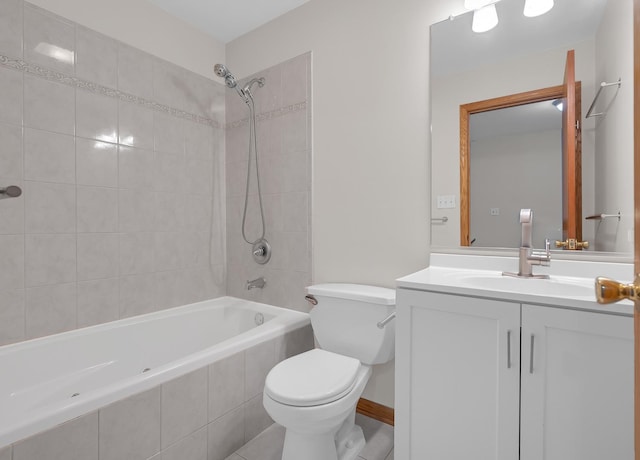 bathroom featuring tiled shower / bath combo, vanity, and toilet