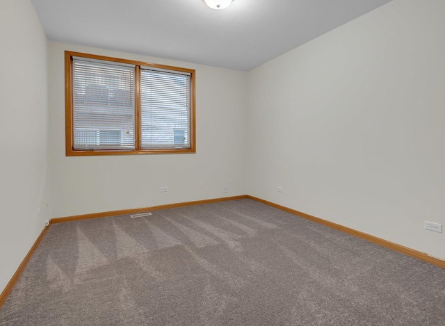 empty room featuring carpet flooring and baseboards