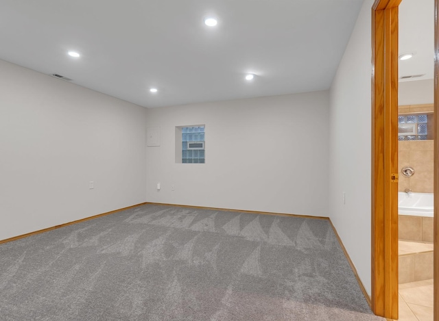 empty room featuring carpet floors, recessed lighting, visible vents, and baseboards