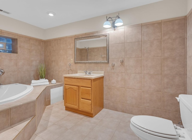 bathroom featuring tile walls, toilet, vanity, tile patterned flooring, and a bath