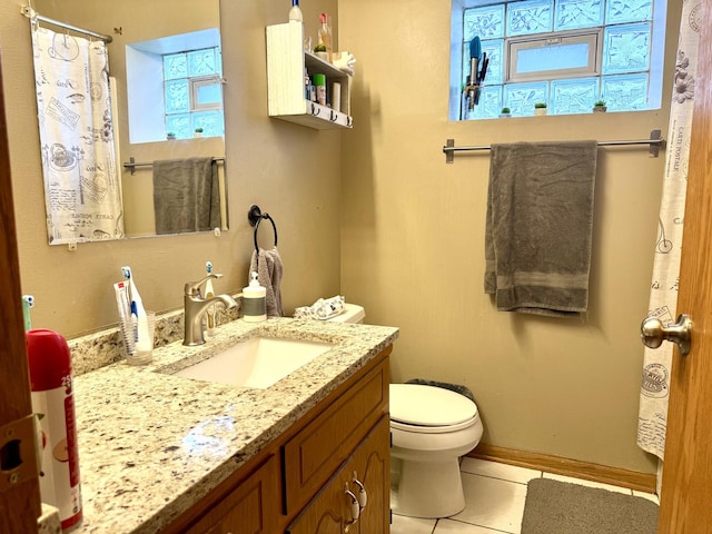 bathroom with a shower with curtain, toilet, vanity, tile patterned flooring, and baseboards