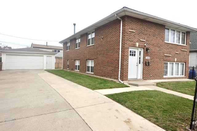 view of front of home featuring brick siding, an outdoor structure, a detached garage, and a front yard