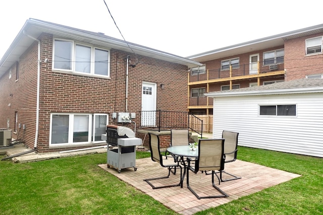 back of house featuring a patio area, brick siding, and a lawn