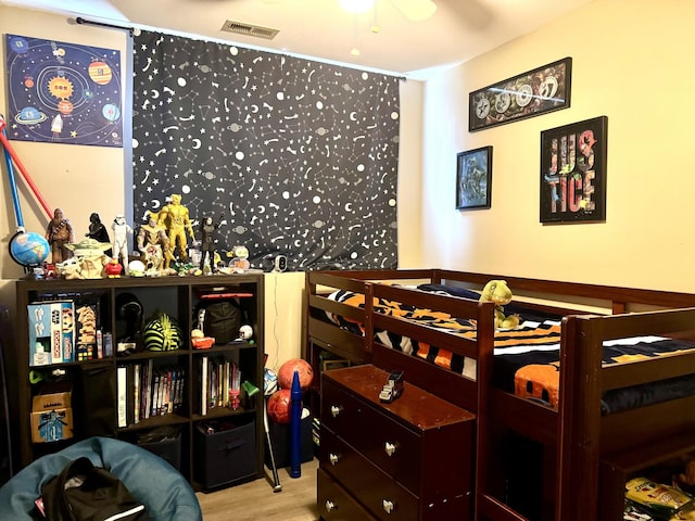 bedroom featuring visible vents and wood finished floors