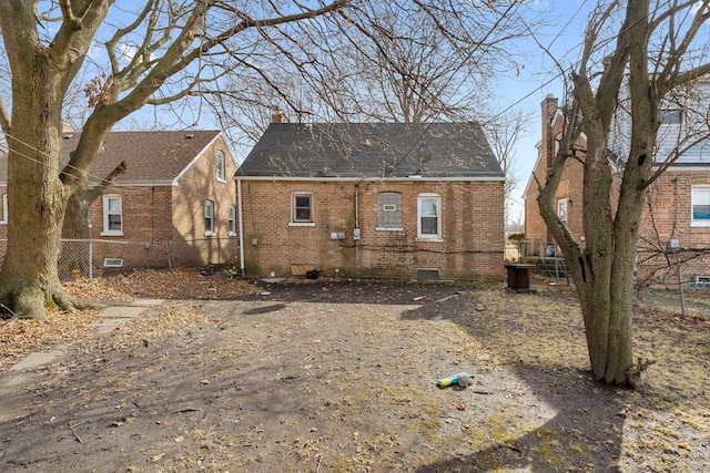 rear view of property with brick siding and fence