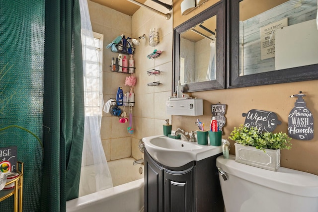 full bath featuring tile walls, vanity, toilet, and shower / tub combo with curtain