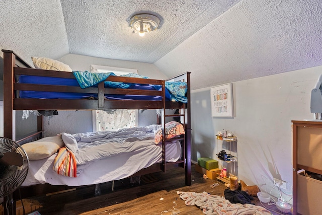 bedroom featuring vaulted ceiling, a textured ceiling, and wood finished floors