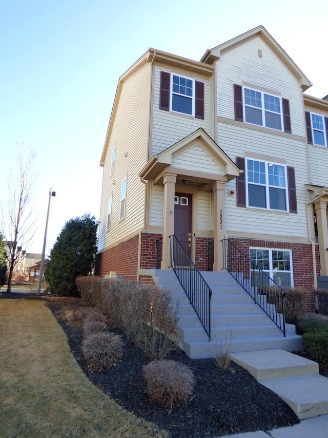 view of front of house with a front yard and brick siding