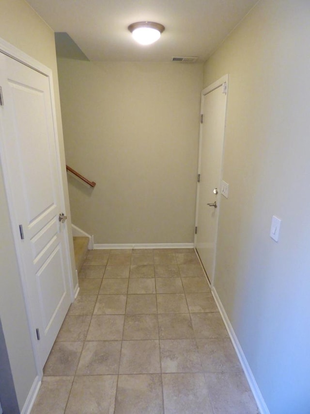 corridor featuring visible vents, stairway, baseboards, and light tile patterned flooring