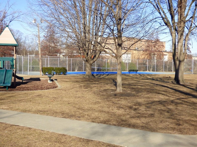 view of yard featuring playground community and fence