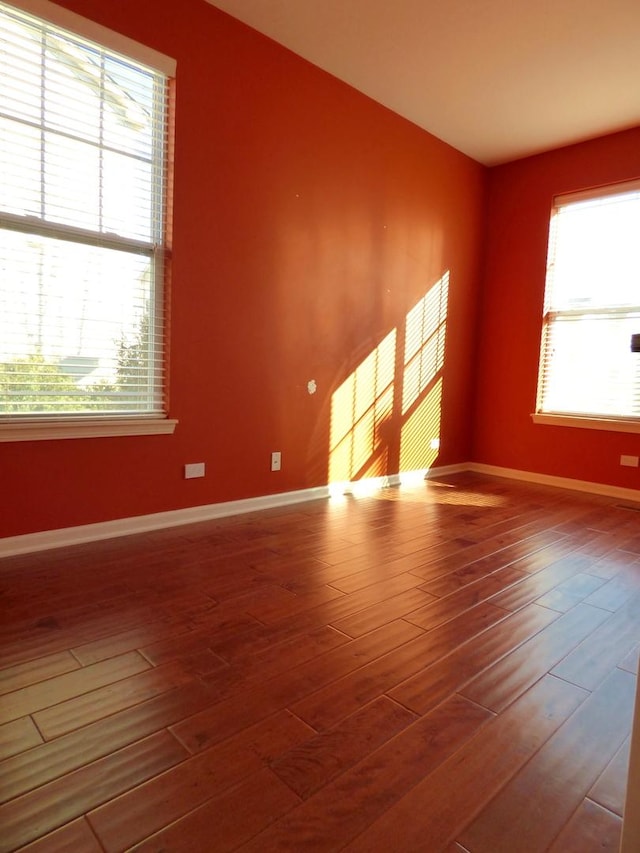 unfurnished room with wood finished floors and baseboards