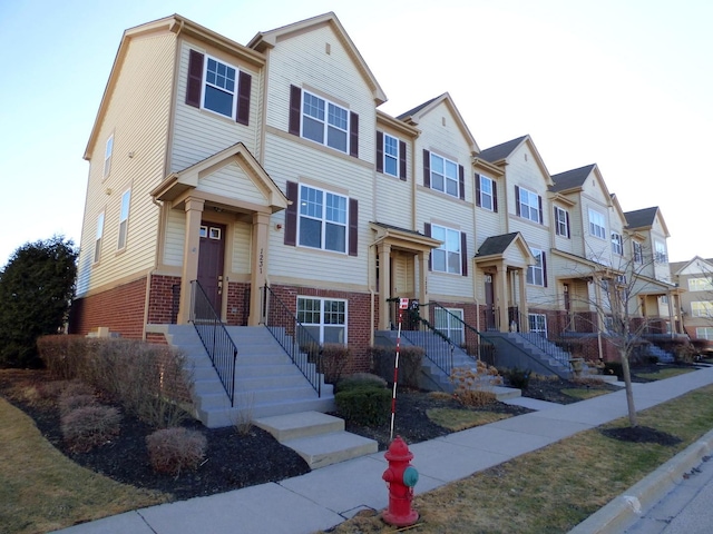 multi unit property featuring a residential view and brick siding