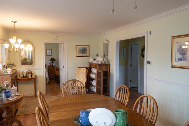 dining room featuring a notable chandelier, crown molding, and wood finished floors