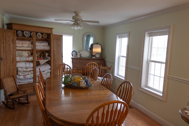 dining area with baseboards, ornamental molding, ceiling fan, and wood finished floors