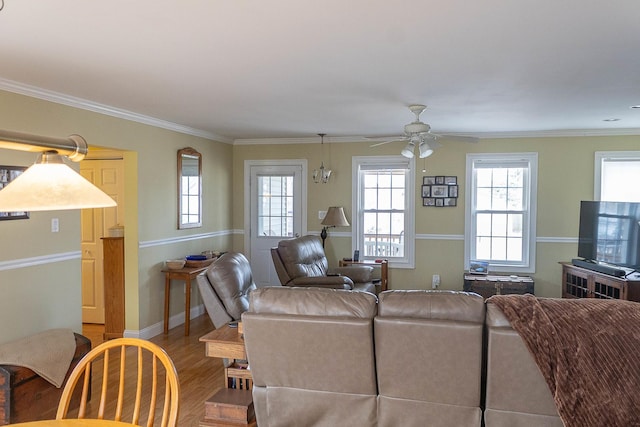 living room featuring baseboards, crown molding, a ceiling fan, and wood finished floors