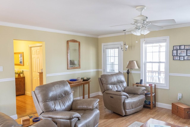 living area with light wood finished floors, ceiling fan, baseboards, and crown molding