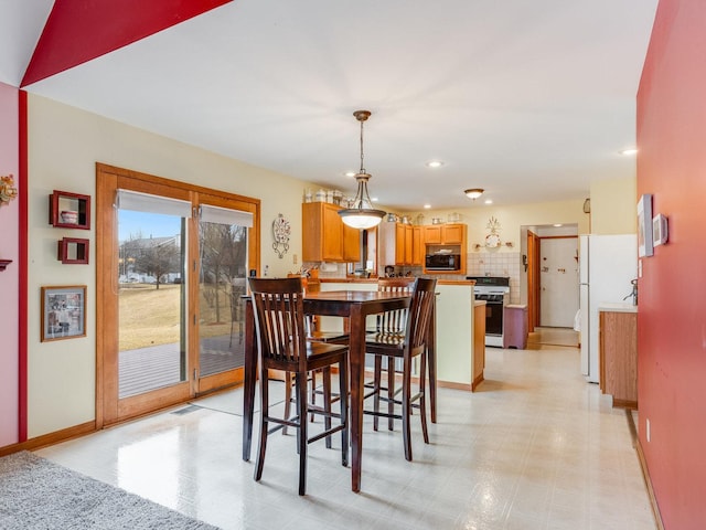 dining area with light floors, baseboards, and recessed lighting