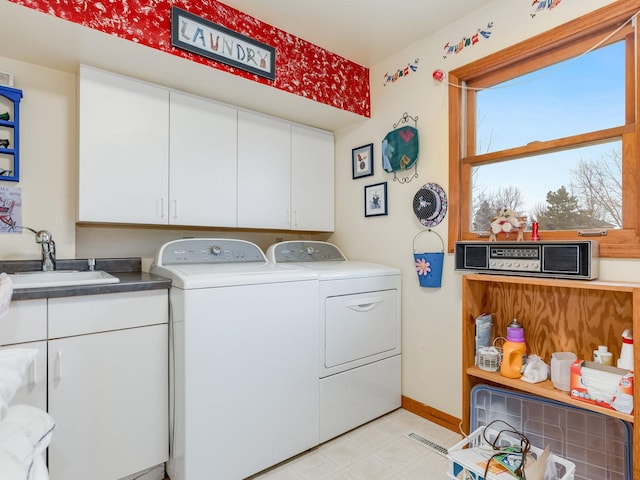 laundry room with separate washer and dryer, a sink, baseboards, cabinet space, and light floors