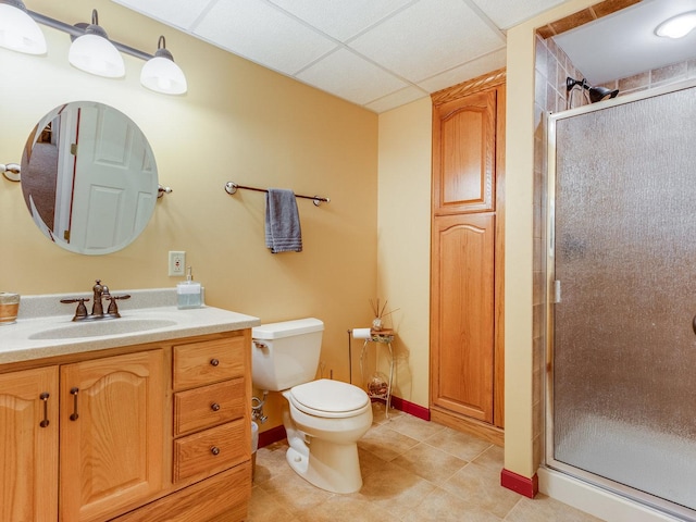 full bath with a paneled ceiling, toilet, vanity, a shower stall, and tile patterned floors