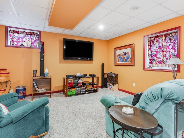 carpeted living area featuring a paneled ceiling and baseboards