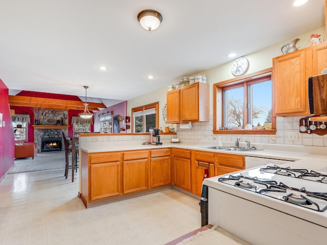 kitchen featuring tasteful backsplash, a sink, a peninsula, and light floors