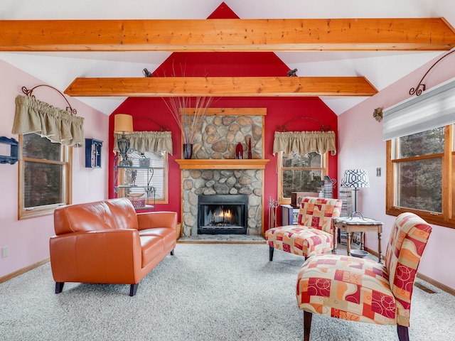 living area with carpet, vaulted ceiling with beams, a stone fireplace, and baseboards