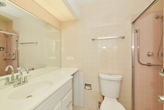 full bathroom with toilet, a shower stall, tile walls, and vanity