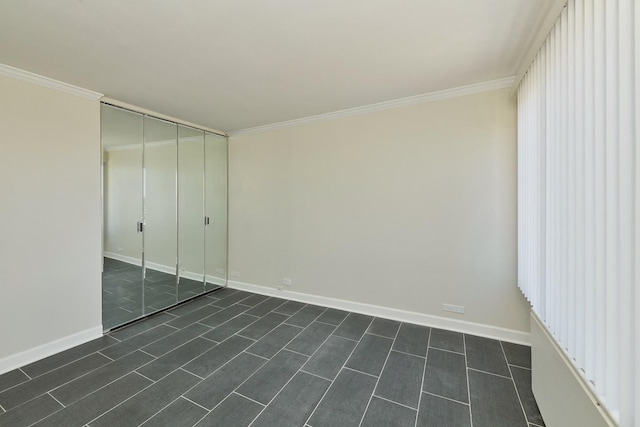 unfurnished bedroom featuring baseboards, ornamental molding, dark wood-style flooring, and a closet