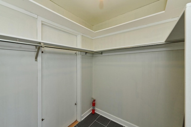 walk in closet featuring dark tile patterned flooring