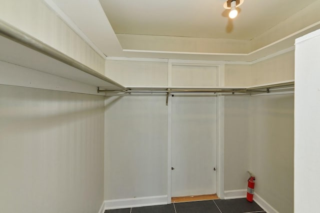 walk in closet with dark tile patterned floors