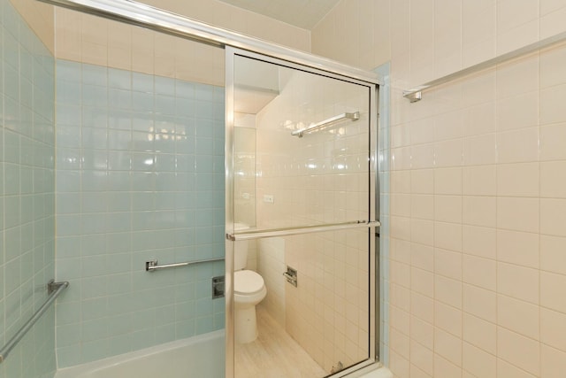 full bathroom featuring toilet, tile walls, and tiled shower