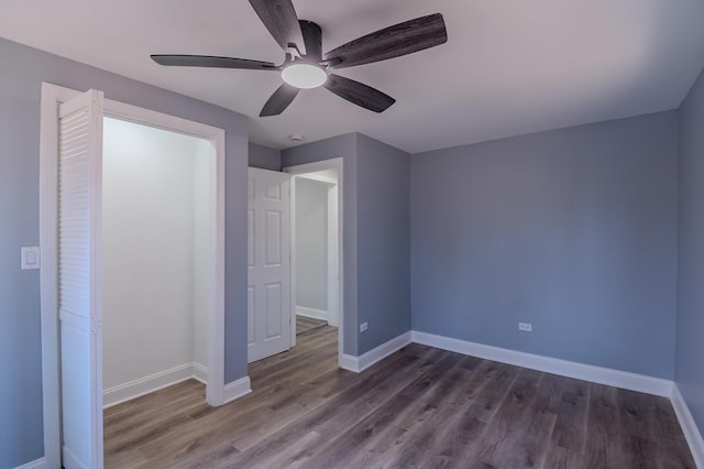 unfurnished bedroom with a ceiling fan, dark wood-style flooring, and baseboards