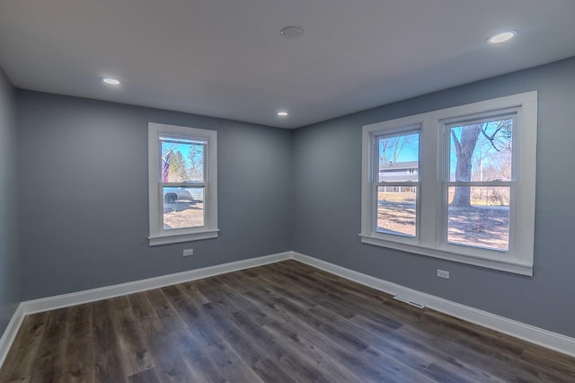 empty room featuring dark wood-style floors, recessed lighting, and baseboards