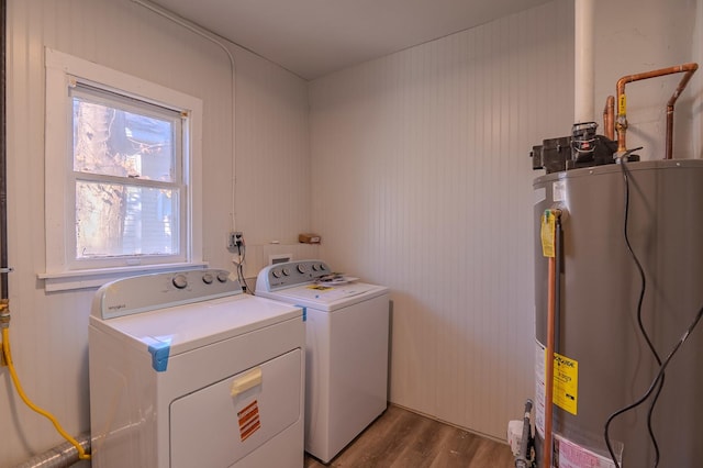 washroom featuring laundry area, water heater, washing machine and clothes dryer, and wood finished floors