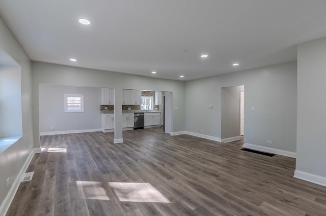 unfurnished living room with recessed lighting, dark wood-style flooring, and baseboards