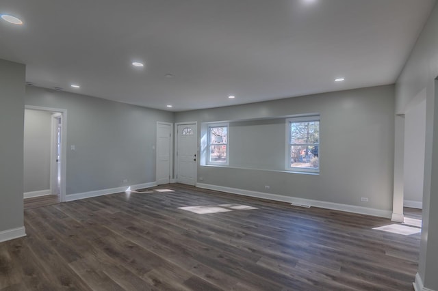 unfurnished room featuring dark wood-type flooring, recessed lighting, and baseboards