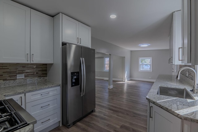 kitchen with a sink, tasteful backsplash, stainless steel fridge, and white cabinetry