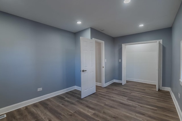 unfurnished bedroom featuring dark wood-style floors, recessed lighting, visible vents, and baseboards