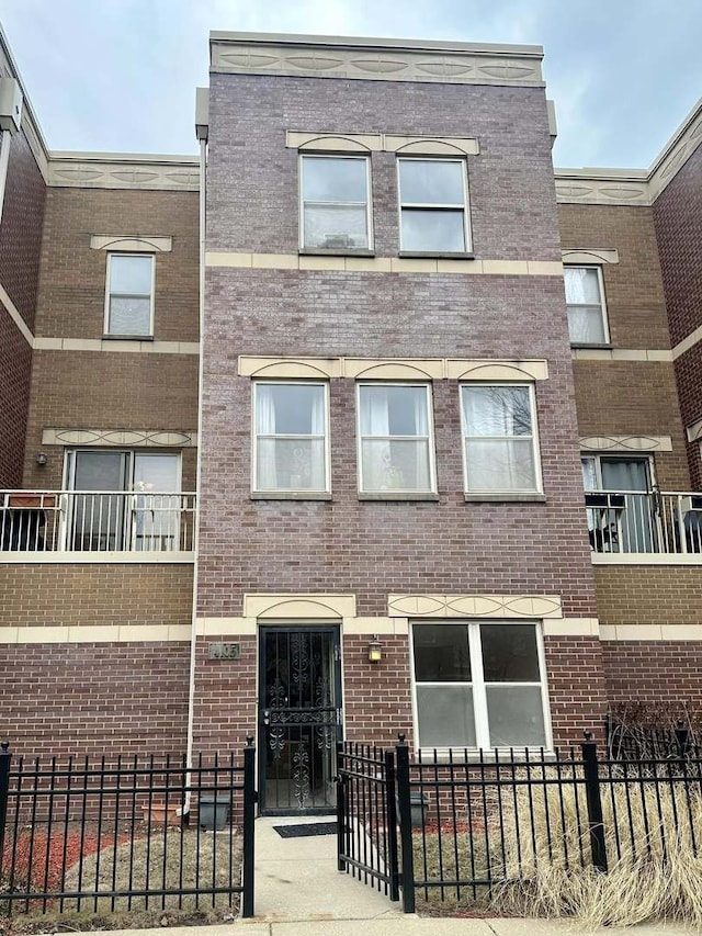 view of front facade with a fenced front yard and brick siding