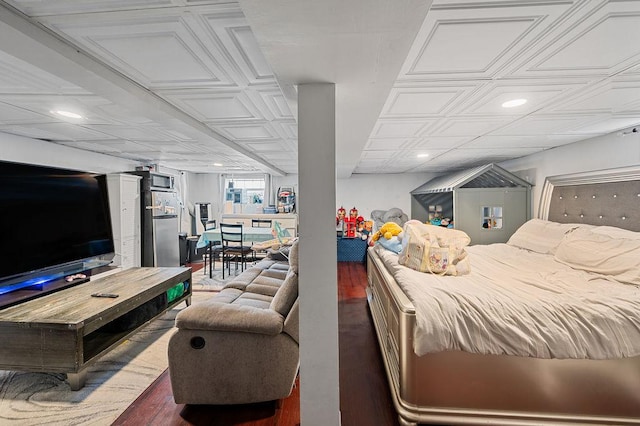 bedroom with an ornate ceiling, freestanding refrigerator, recessed lighting, and wood finished floors