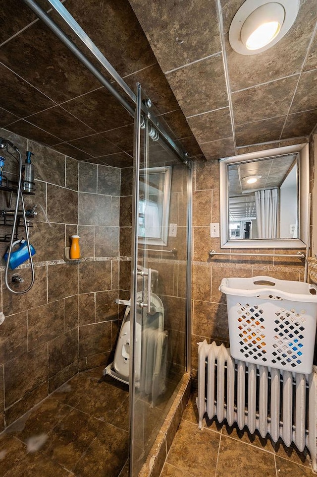 bathroom with radiator heating unit and a shower stall