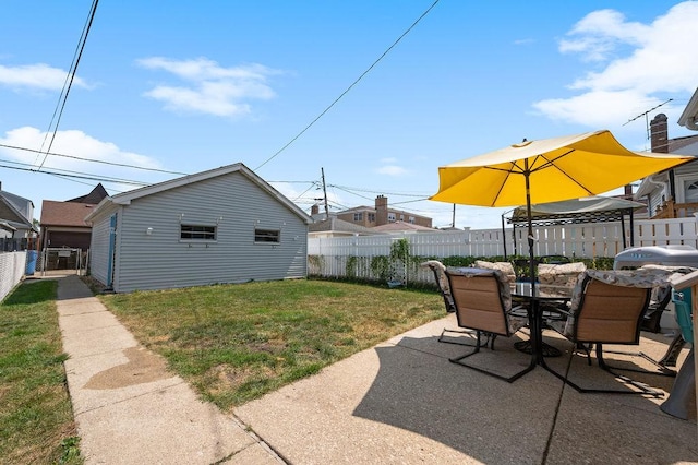 view of yard featuring a patio, outdoor dining space, an outdoor structure, and a fenced backyard