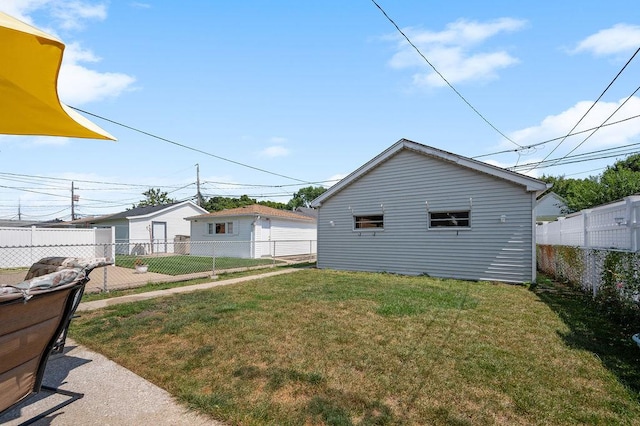 view of home's exterior with an outbuilding, a fenced backyard, and a yard