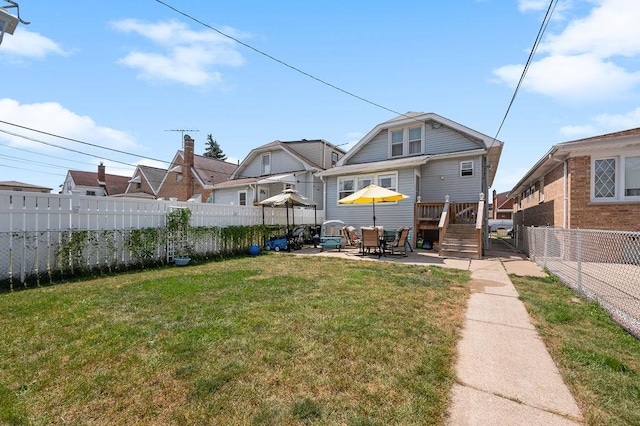 rear view of property with a lawn, a patio area, and a fenced backyard