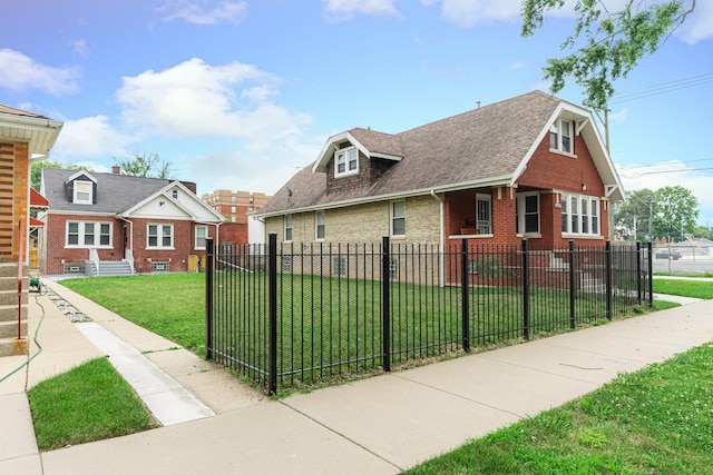 view of front of house featuring a fenced front yard, a front yard, brick siding, and roof with shingles