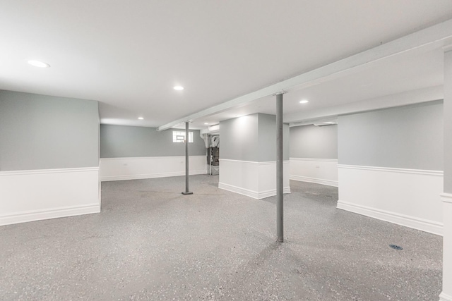 basement featuring a wainscoted wall and recessed lighting