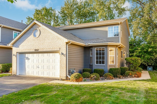 traditional-style home with brick siding, an attached garage, and a front yard