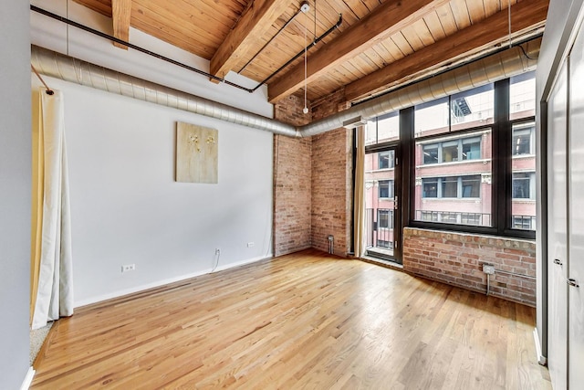 empty room featuring wood ceiling, beamed ceiling, brick wall, and wood finished floors