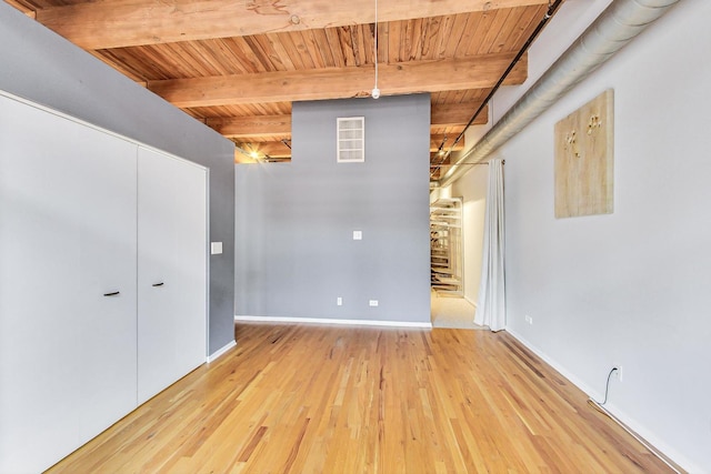 unfurnished room with beam ceiling, visible vents, wood finished floors, wooden ceiling, and baseboards