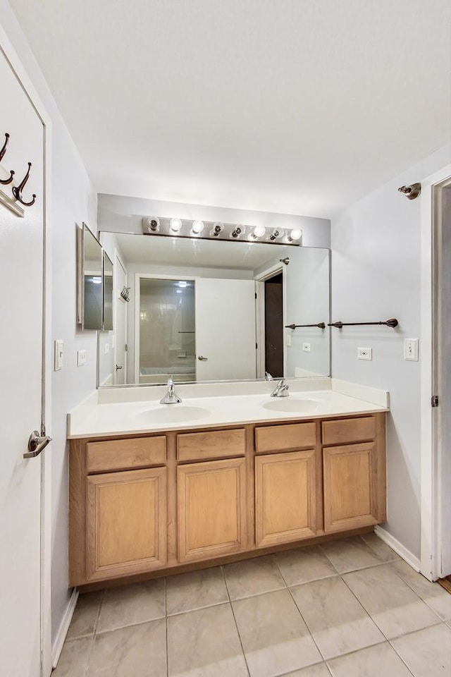 bathroom with double vanity, a sink, and tile patterned floors